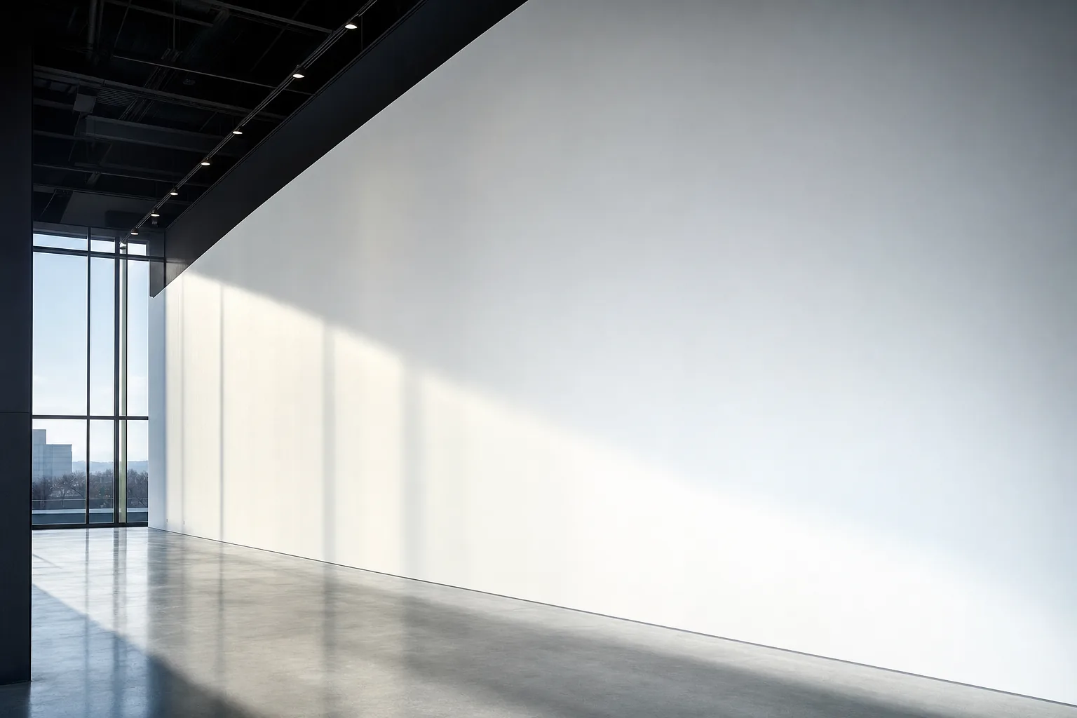 A Level 5 finished drywall wall in a commercial interior under raking daylight